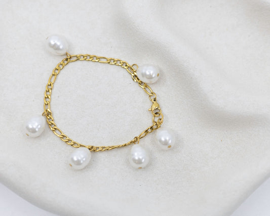 gold bracelet with pearl charms on white background