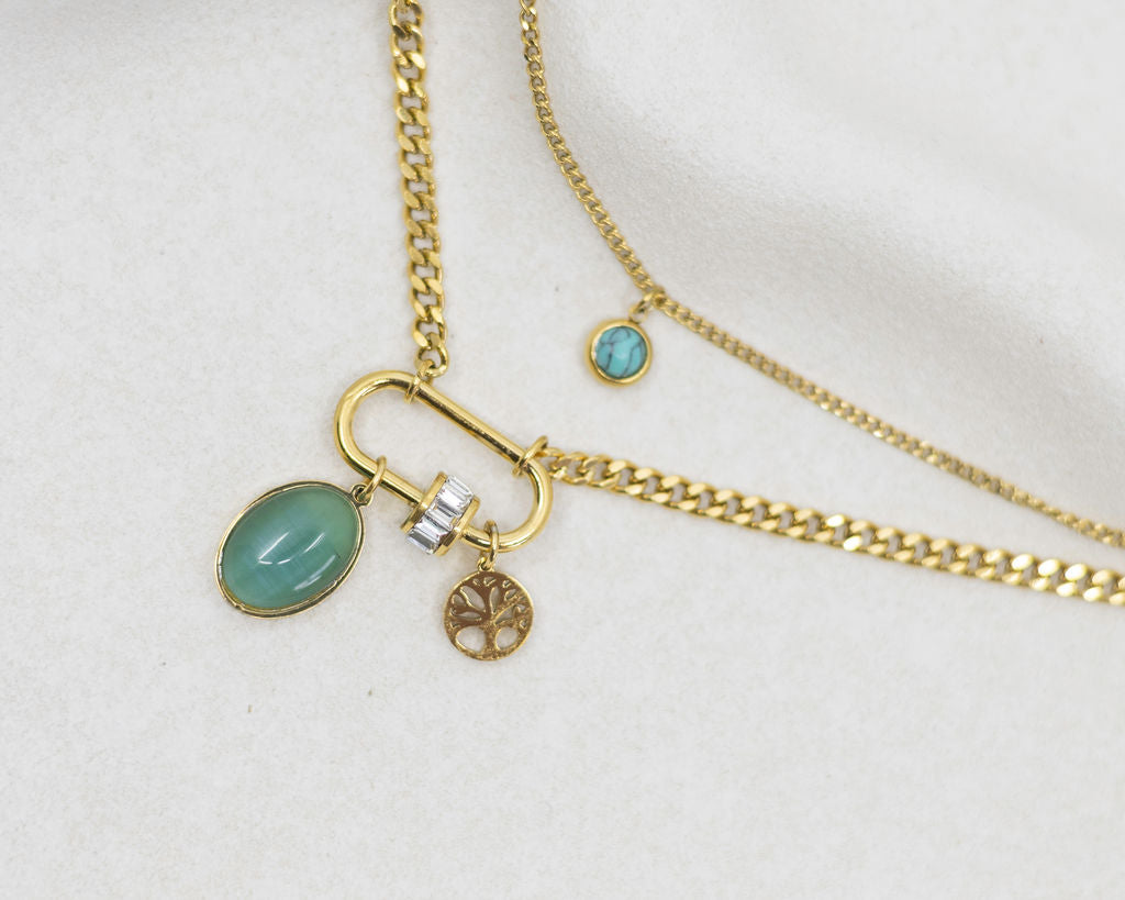 Gold necklace with charms on a white background
