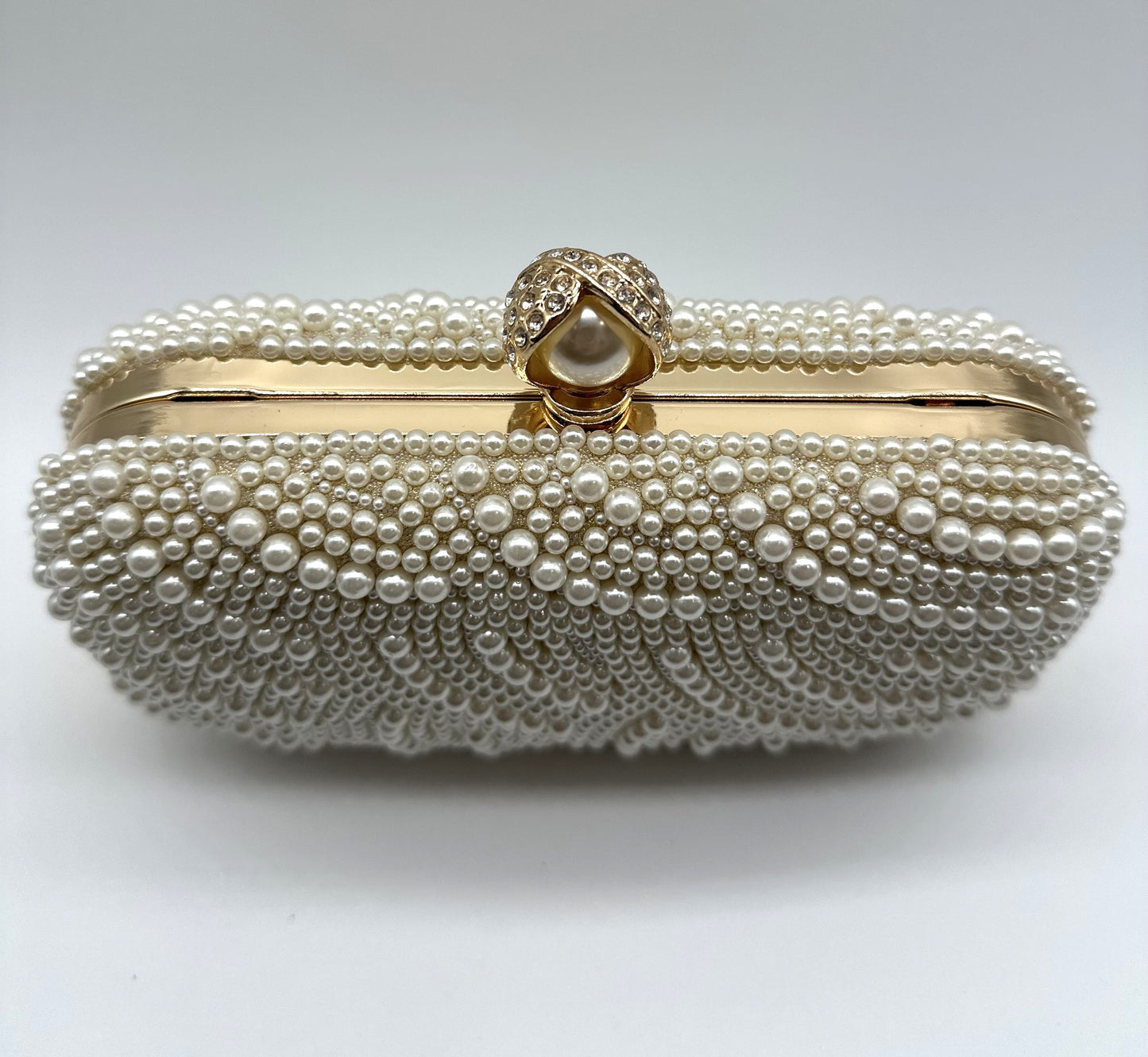 Pearl-handled clutch bag on a white background
