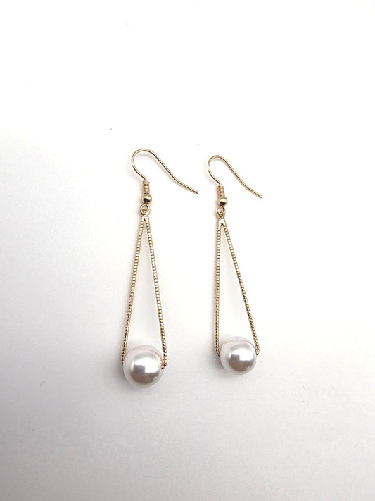 Pair of pearl drop earrings on a light gray background