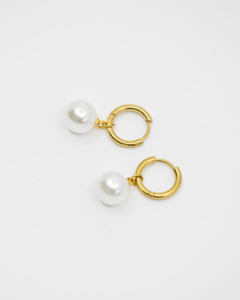 Pair of gold hoop earrings with pearls on a white background