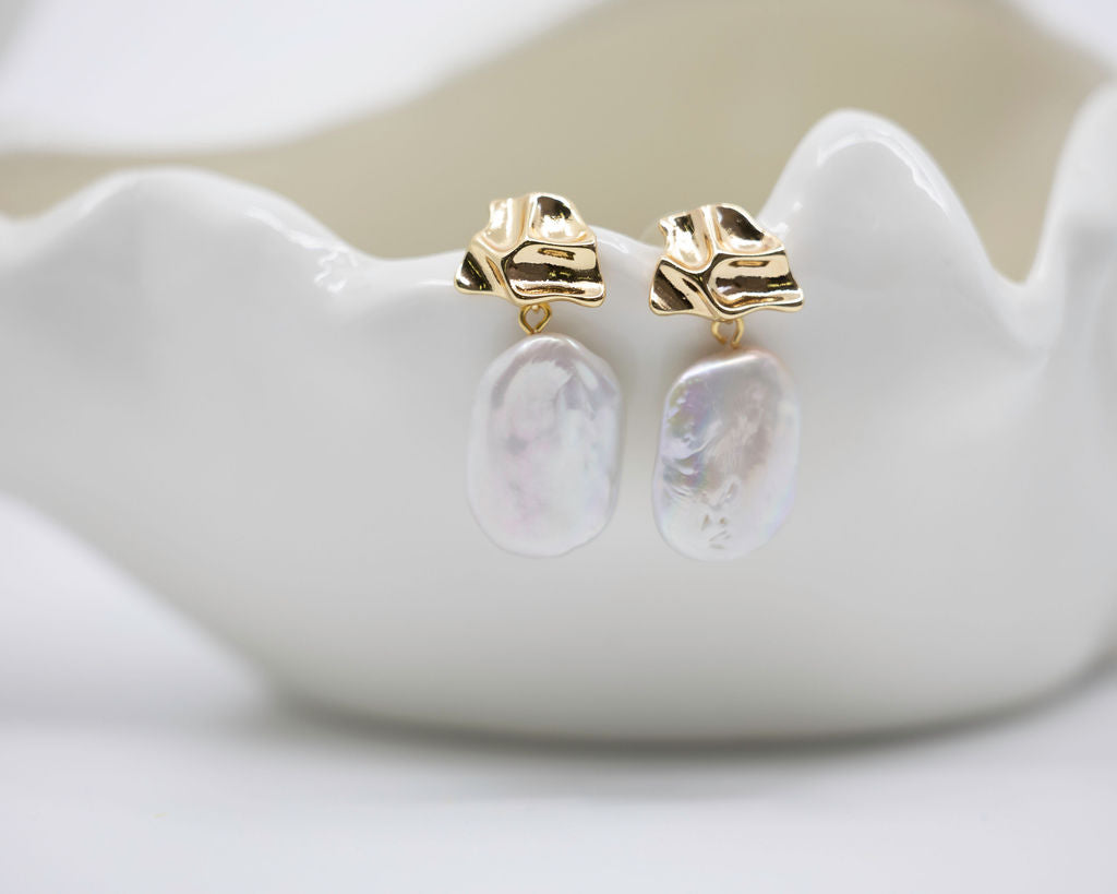baroque pearl and gold earrings on white background