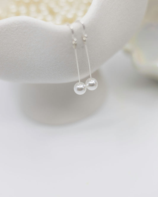 Pearl necklace on a white stand with a blurred background
