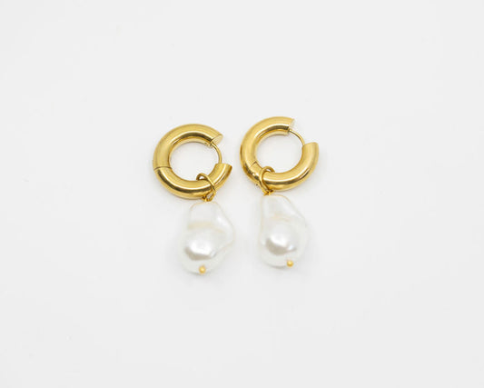 Gold hoop earrings with pearl drops on a white background
