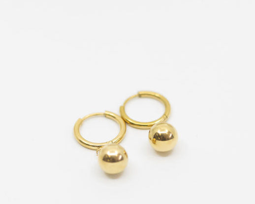 Gold earring with hoops and two gold ball drops on a white background