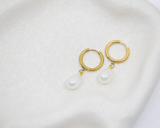gold hoop earrings with pearl drop on white background