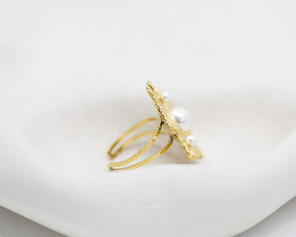Gold ring with pearls on a white surface