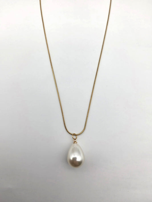 Pearl necklace on a thin chain against a light gray background