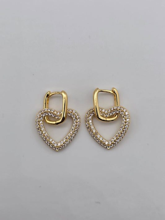 Pair of gold heart-shaped earrings on a gray background