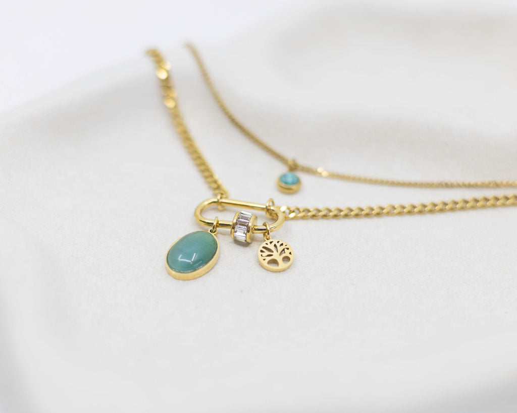 Two gold necklaces with turquoise charms on a white background