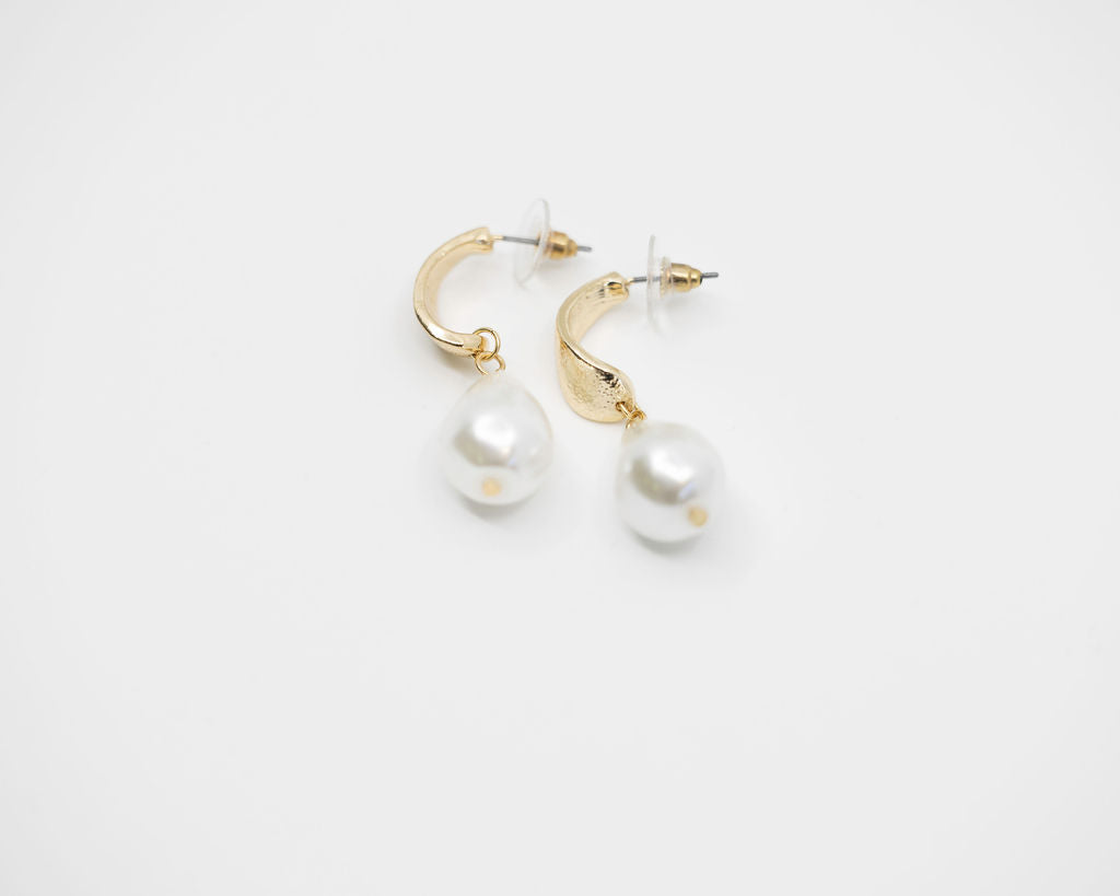 gold pearl earrings on white background