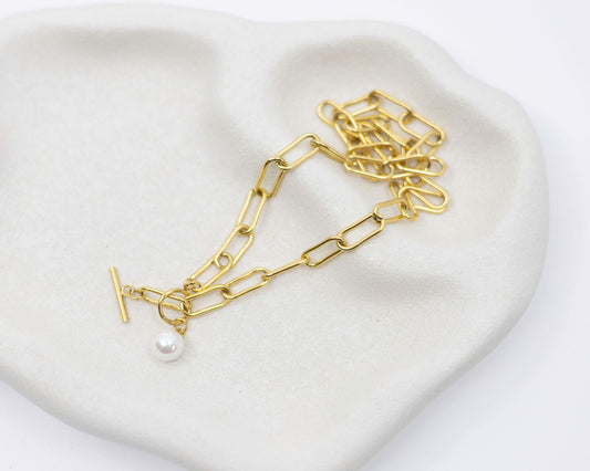 gold link chain and pearl necklace on white background