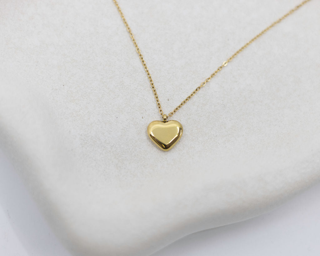 Gold heart-shaped pendant necklace on a white background