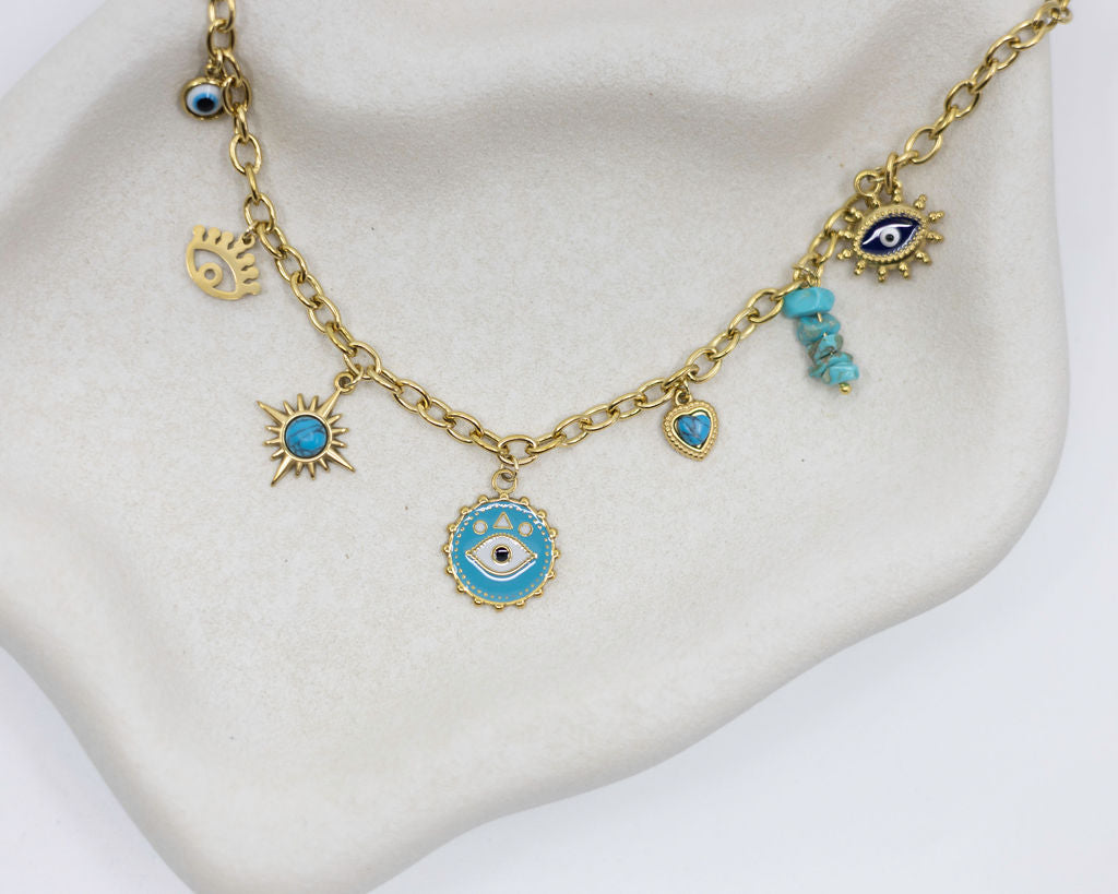 Gold necklace with blue evil eye charms on a white stand