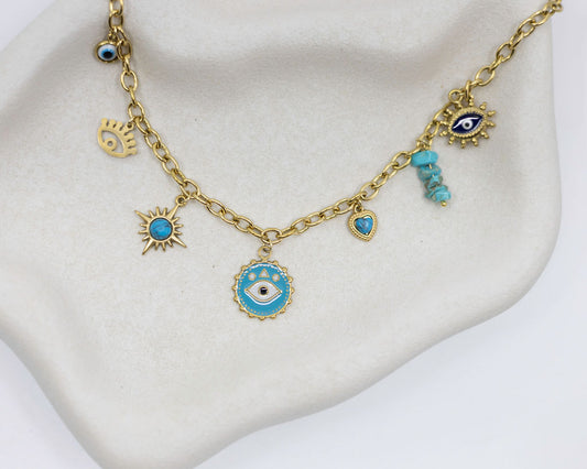 Gold necklace with blue evil eye charms on a white stand