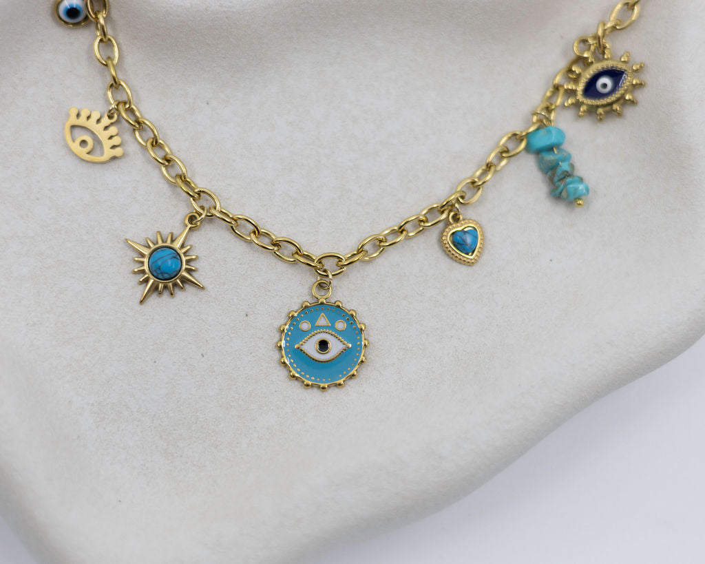 Gold necklace with blue eye charms on a white background
