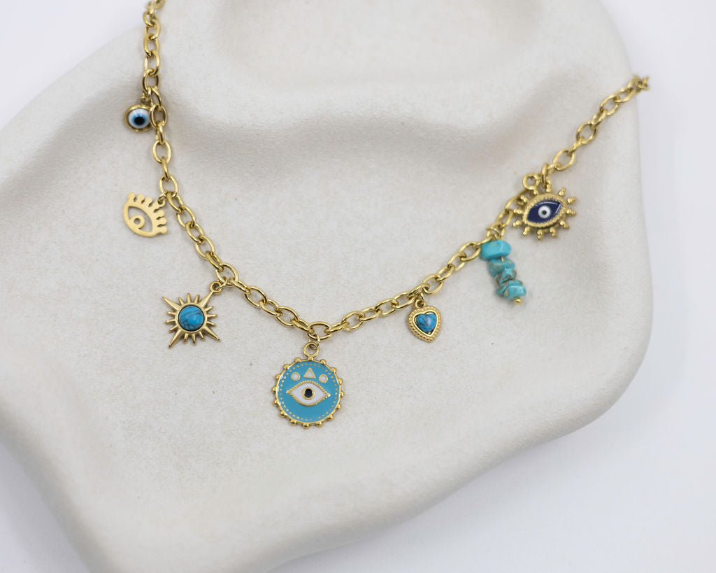Gold necklace with blue eye charms on a white stand