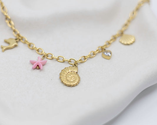 Gold necklace with sea charms on a white background