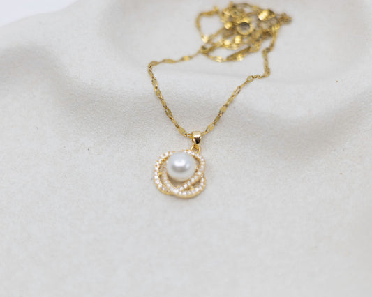 gold necklace with pearl and crystals on white background