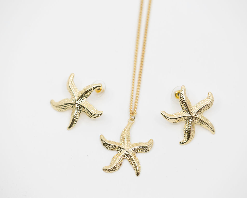 Gold starfish necklace and earrings on a white background