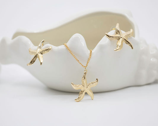 Gold starfish jewelry set including earrings and a necklace on a white background