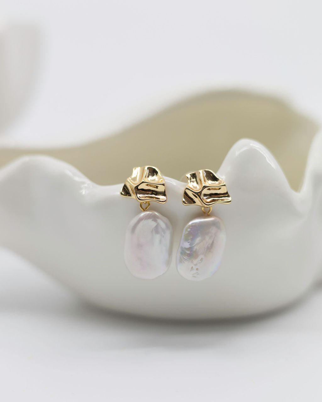baroque pearl and gold earrings on white background
