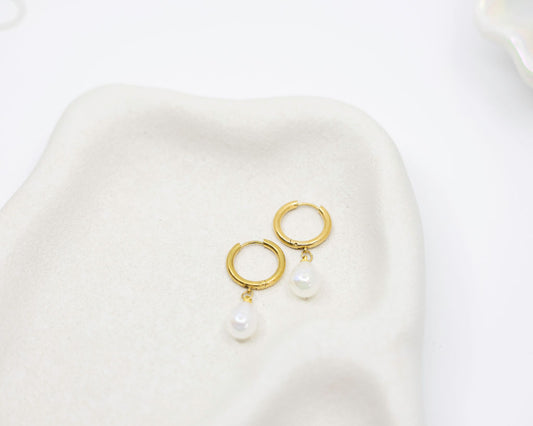 gold hoop earrings with pearl drop on white background