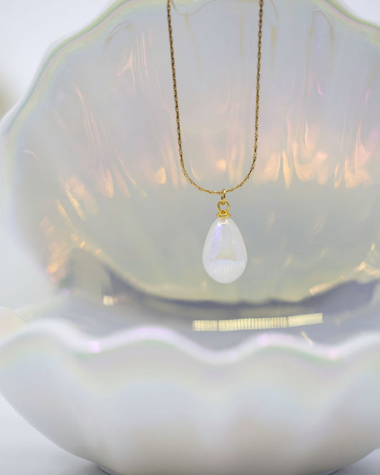 gold necklace with pearl drop on white background