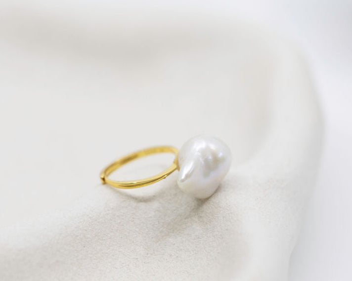 Pearl ring with gold band on a white background