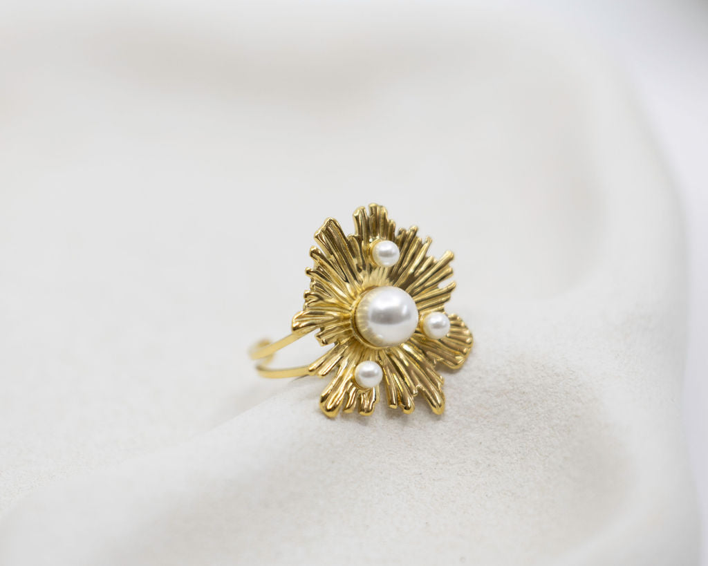 Gold ring with pearl accents on a white background