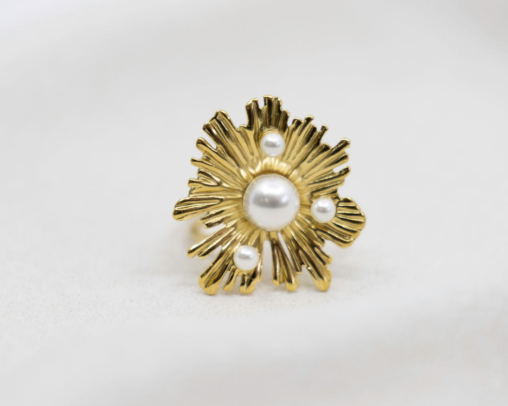 Gold ring with pearl center on a white background