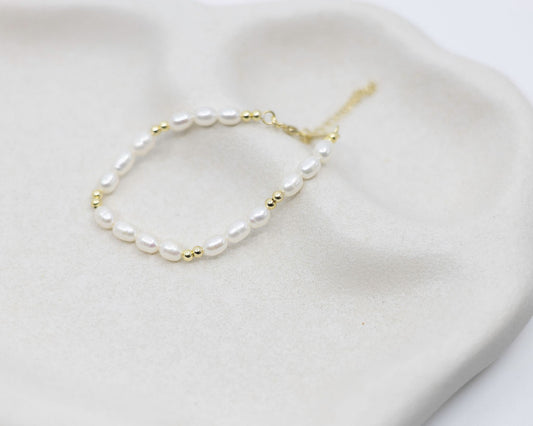Pearl bracelet with gold accents on a white surface