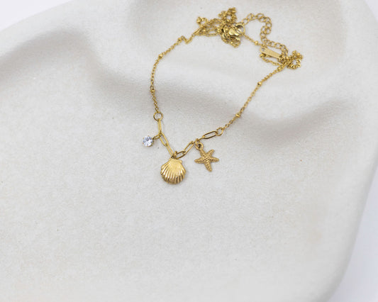 Gold bracelet with charms on a white background