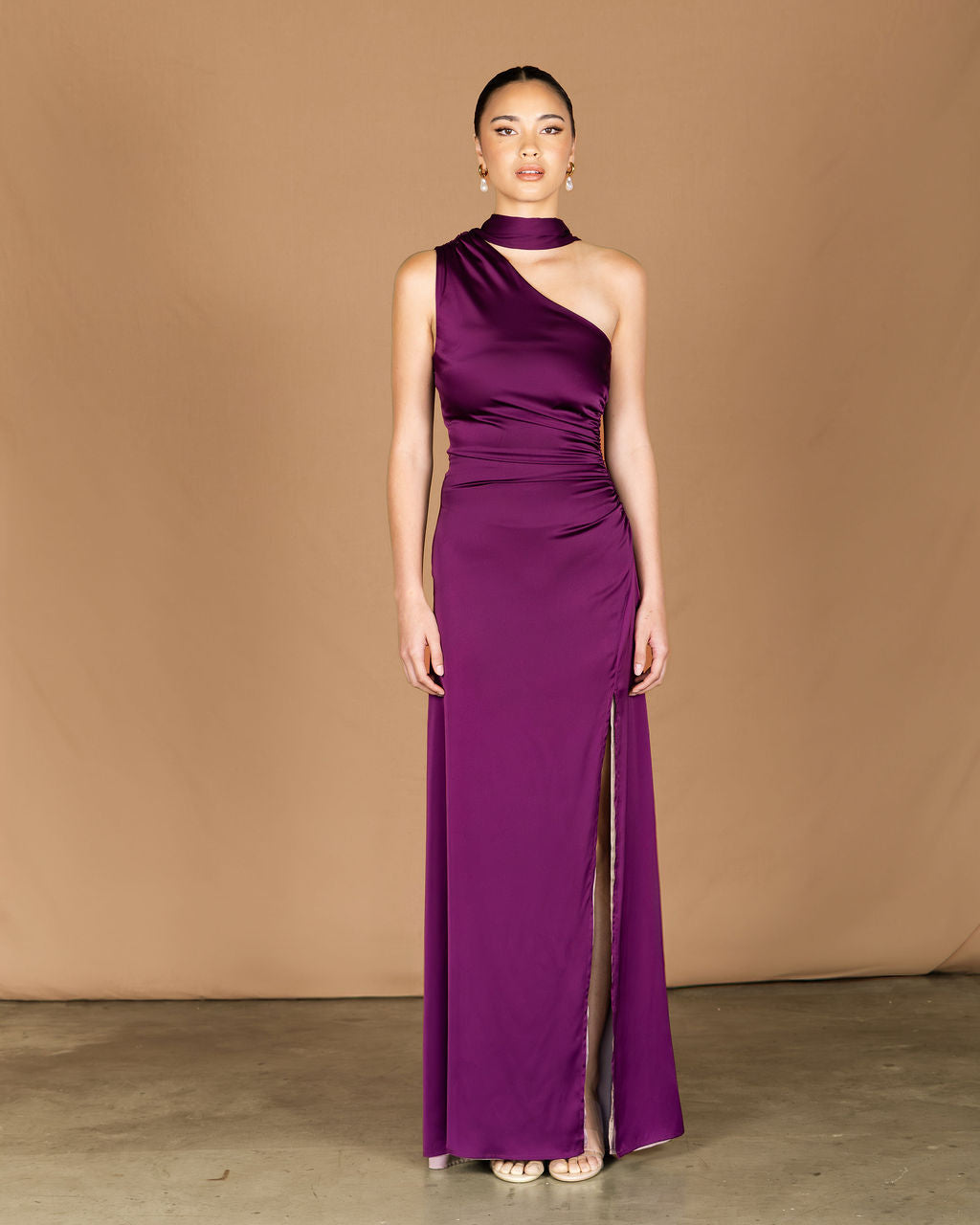 Woman wearing a purple one-shoulder gown, one shoulder gown, reversible dress