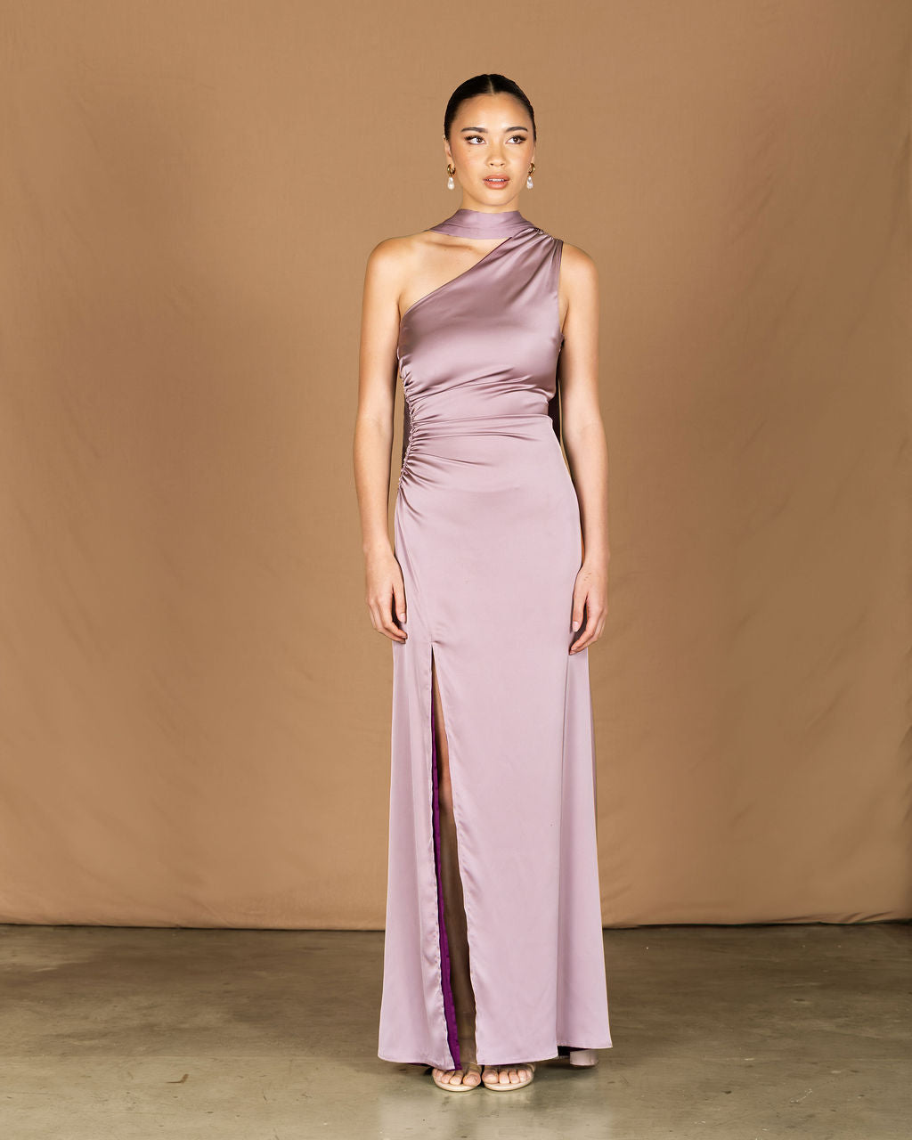 Woman wearing a long, one-shoulder lavender dress, bridesmaid dress
